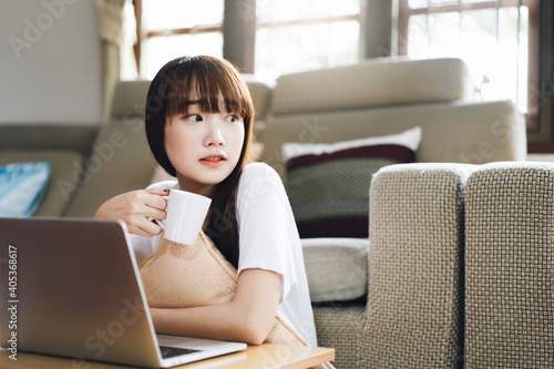 Young adult asian woman work and study at home on virus pandemic social issuse. photo