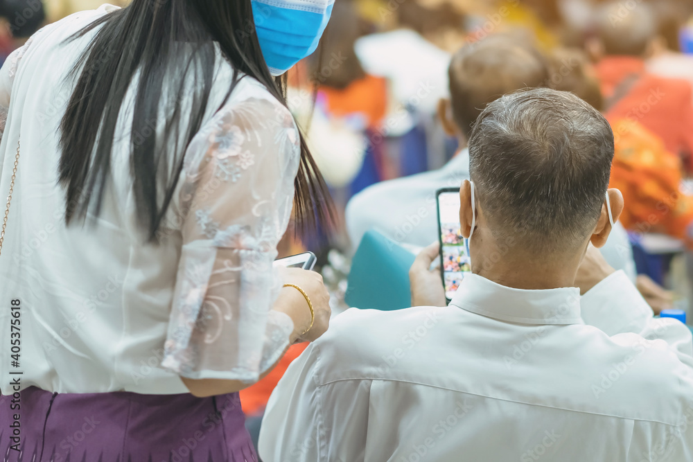 Back view of Asian man wear protective face mask to prevent Coronavirus(COVID-19) sitting on a chair for social distancing in auditorium. Conference concept in coronavirus pandemic.Selective focus. Back view of Asian man wear protective face mask to prevent Coronavirus(COVID-19) sitting on a chair for social distancing in auditorium. Conference concept in coronavirus pandemic.Selective focus.