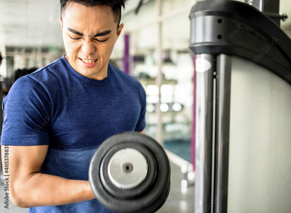 young man training with dumbbell in the gym young man training with dumbbell in the gym