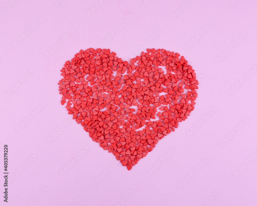 heart-shaped confectionery sprinkling on pink background