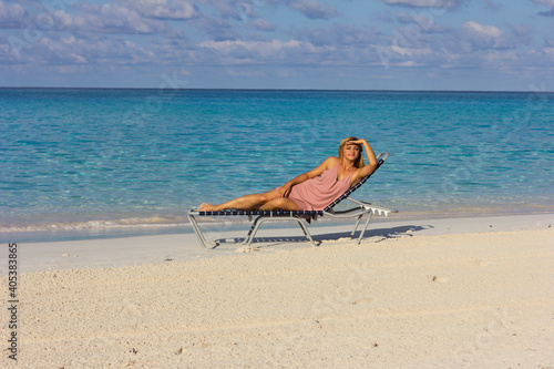 Fototapeta Naklejka Na Ścianę i Meble -  Young beautiful woman is relaxing on the beach