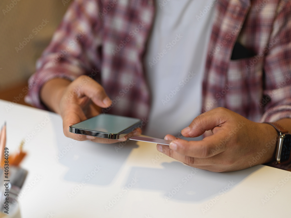 Businessman using smartphone on white table in office room Businessman using smartphone on white table in office room