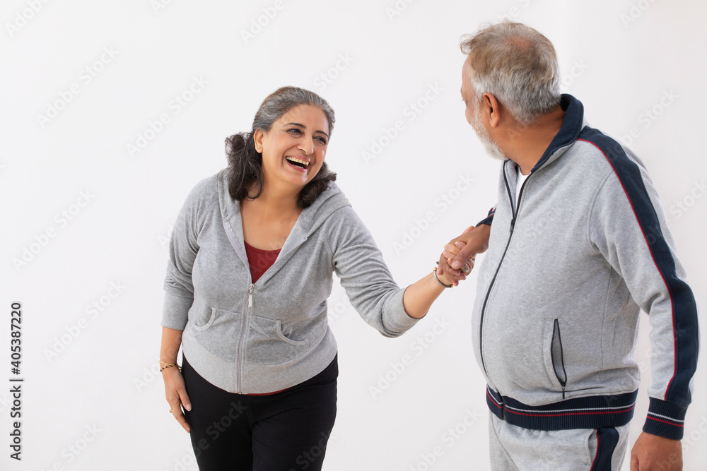 PLAYFUL SENIOR COUPLE HAVING FUN WHILE WALKING TOGETHER PLAYFUL SENIOR COUPLE HAVING FUN WHILE WALKING TOGETHER