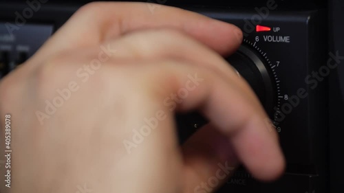 Close-up of a man's hand adjusting the volume on the tape recorder. Turn down the volume