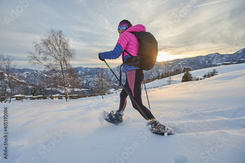 Girl in action with snowshoes during twilight