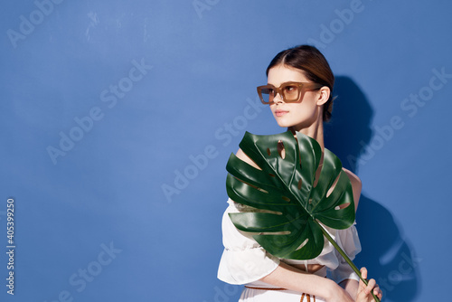 Woman wearing sunglasses palm cosmetics summer travel blue background
