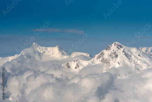 aerial view of snow capped mountains with clouds in blue sky Karakorum range Pakistan  photo