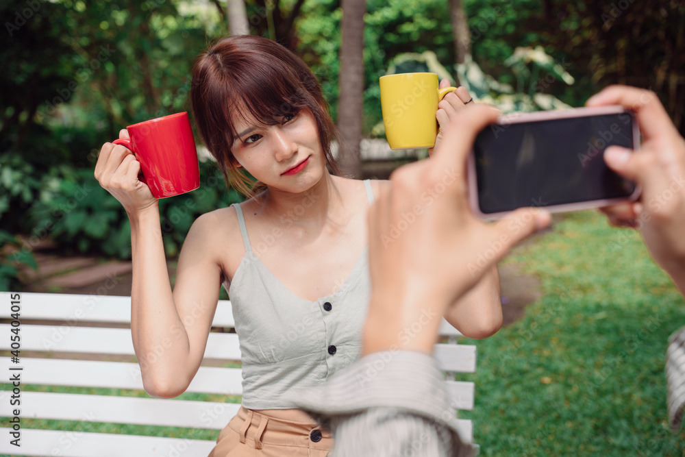 Asian thai couple taking photo with smartphone at park outdoors. Asian thai couple taking photo with smartphone at park outdoors.