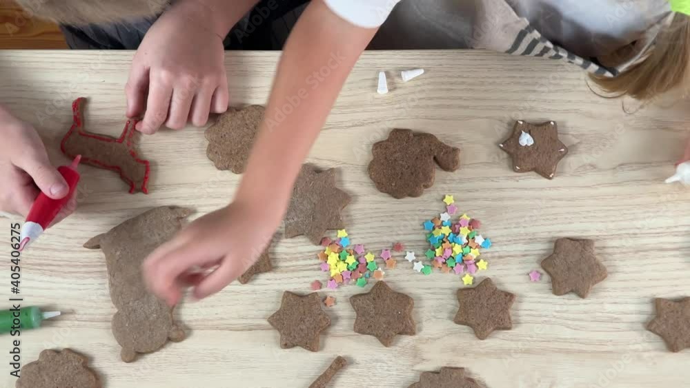 Little girl and boy decorating gingerbread on the kitchen Little girl and boy decorating gingerbread on the kitchen