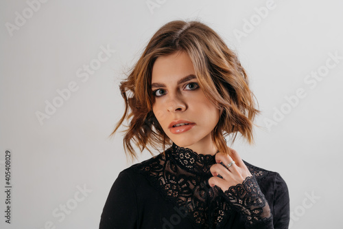 Portrait of a brunette woman in a photo studio haircut under a square
