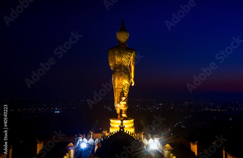 Golden buddha standing statue on a mountain Wat Phra That Khao Noi at sun rises, Nan Province, Thailand