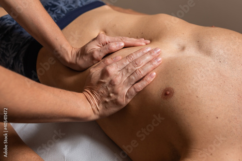 Woman physiotherapist does session to man. visceral ostropathy
