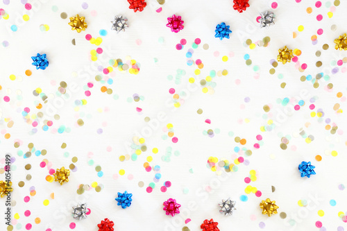 Party colorful confetti over white wooden background . Top view, flat lay photo