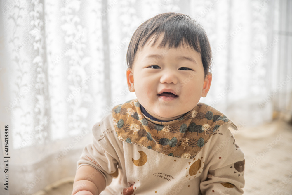 リビングでリモコンで遊ぶ赤ちゃん リビングでリモコンで遊ぶ赤ちゃん
