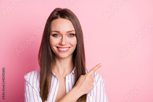Photo of shine lovely young woman dressed casual white clothes pointing empty space isolated pastel pink color background