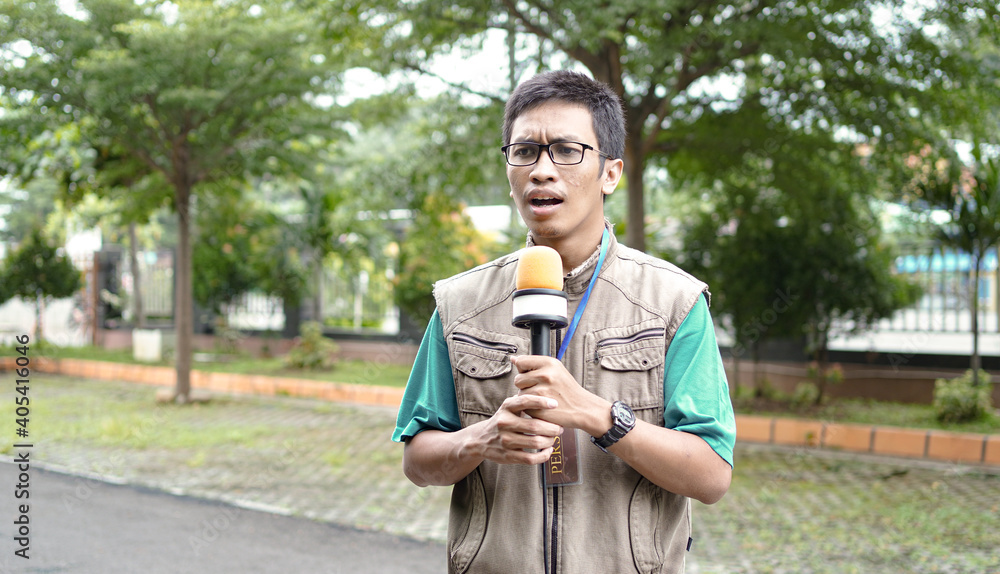 Fototapeta premium asian male journalist wear vest and ready for news