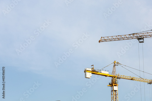 Industrial construction cranes and building. Working construction crane tower on the clear sky background