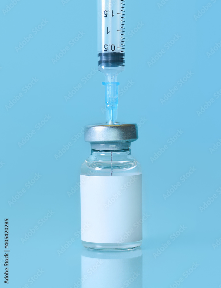 Vaccine in a bottle with a syringe on a blue background.The concept of medicine, healthcare and science.Coronavirus vaccine.Copy space for text. Vaccine in a bottle with a syringe on a blue background.The concept of medicine, healthcare and science.Coronavirus vaccine.Copy space for text.