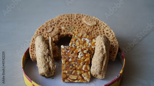 Close up view of pieces of Half Ghevar, Sesame bar and penaut dessert isolated on white background. Indian festivals sweets concept. photo