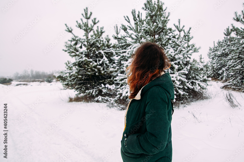 Girl looking at the snowy road in the forest Girl looking at the snowy road in the forest