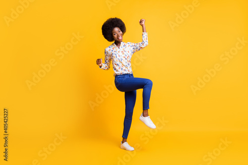 Full length photo of adorable lucky dark skin lady dressed casual outfit rising fists isolated yellow color background