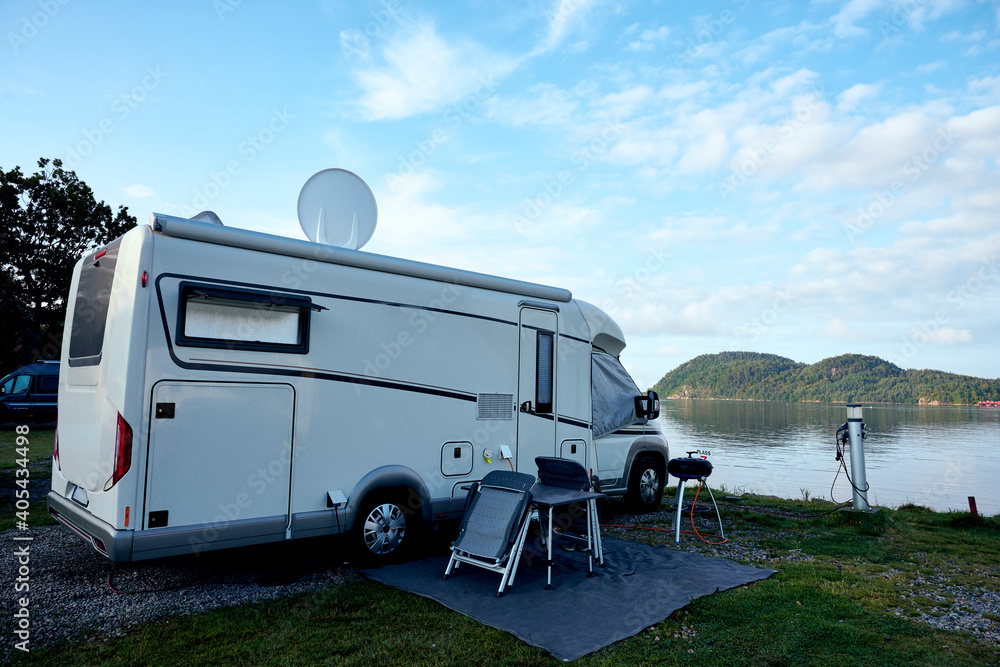 Schönes Camping mit dem Wohnmobil an einem See mit blauem Himmel. 