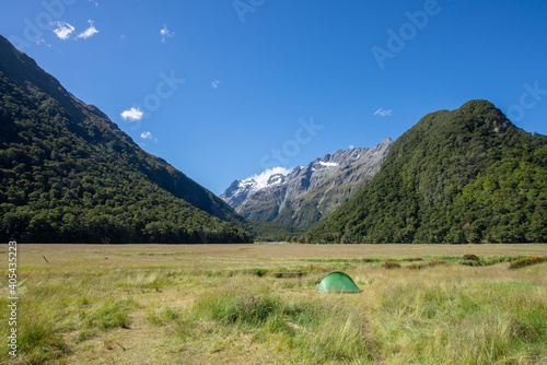 Camping in tent among the mountain valley at Falls Hut camp site, Routeburn Track, Fjordland National Park, Southland, New Zealand photo