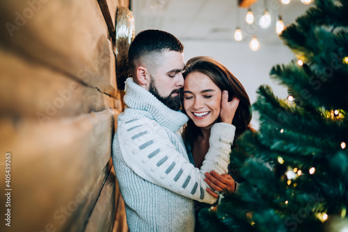 Fotografia Cheerful couple embracing near Christmas tree