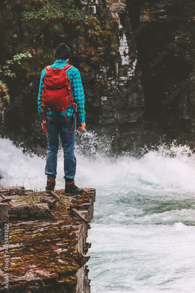 Obraz premium Man adventurer with backpack hiking alone travel lifestyle active vacations outdoor traveler enjoying river canyon view in Sweden