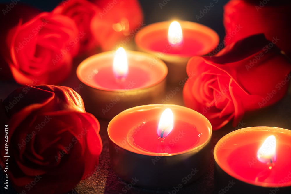 Red roses and burning candles, close up, romantic greeting card. concept of Valentine's Day. Red roses and burning candles, close up, romantic greeting card. concept of Valentine's Day.