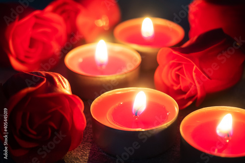 Red roses and burning candles, close up, romantic greeting card. concept of Valentine's Day.
