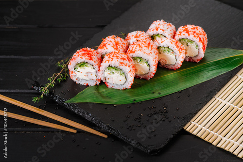 Fresh and tasty sushi rolls on black background