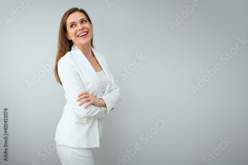 Business woman in white business suit standing with crossed arms and looking away.
