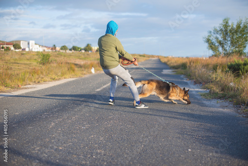 Young man being pulled by his german shepherd dog