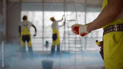Tableau sur toile Close up of construction worker putting on gloves working in office