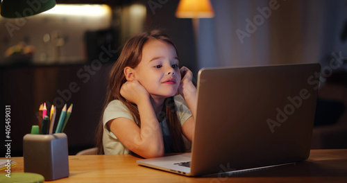 Happy smiling preteen student girl with laptop having video call at home