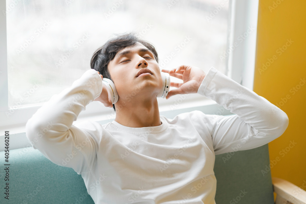 Asian man sitting, enjoying music Asian man sitting, enjoying music