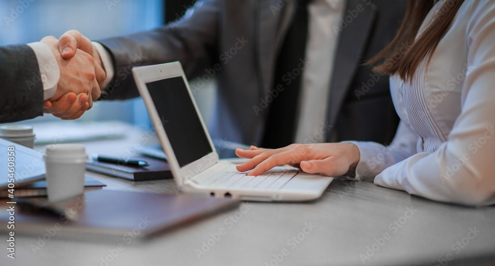 business colleagues shaking hands over a work Desk. close up. business colleagues shaking hands over a work Desk. close up.