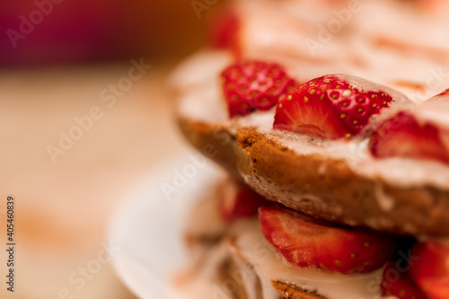 Pastries with red berries and white cream. Cake with strawberries and sour cream. Close-up. Food. Copy space. Selective focus.