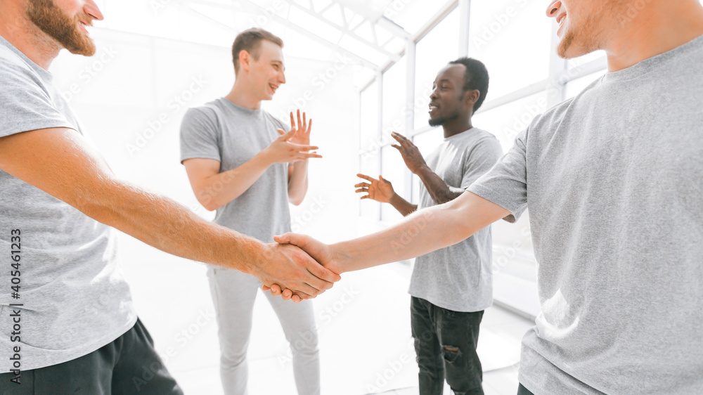 Obraz premium welcome handshake of friends in a bright office.