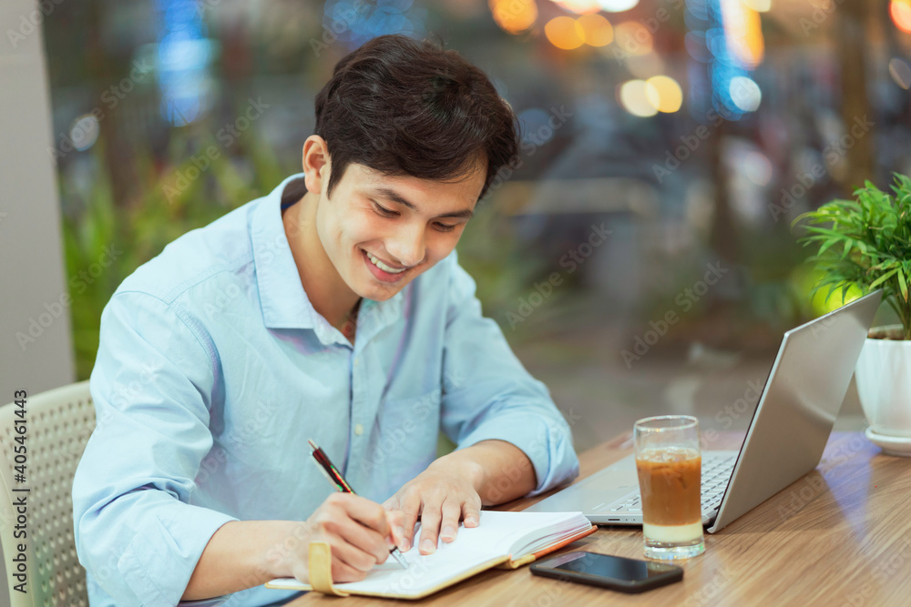 Asian man sitting working alone at a coffee shop Asian man sitting working alone at a coffee shop