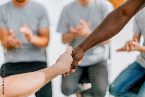 close up. friends the participants of the workshop, shaking hands with each other