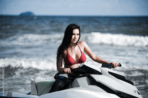 Asian female in bikini sitting on jet ski. © ic36006