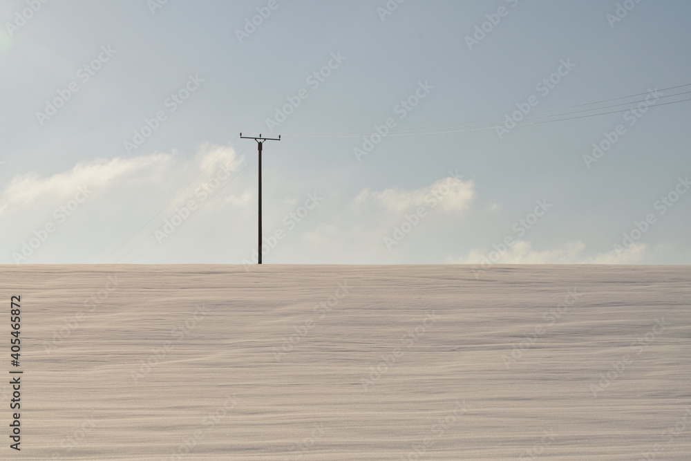 Strommast in Schneelandschaft