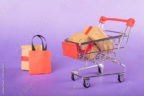  miniature shopping cart with bags and some boxes.