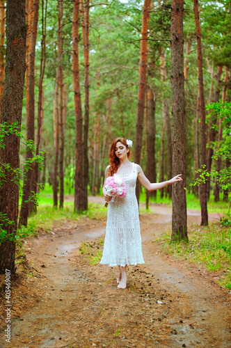 Outdoor portrait of young redhead woman in vintage wedding dress with big bouquet of pink peonies. Woman's Day. Female spring, summer fashion concept. Wedding day.