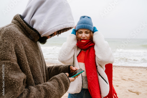 Beautiful young couple using mobile phone