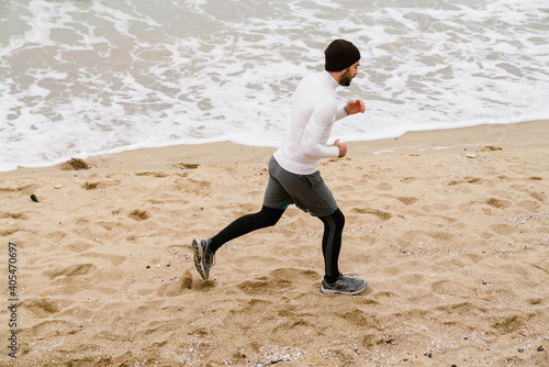 Young sportsman running at the beach