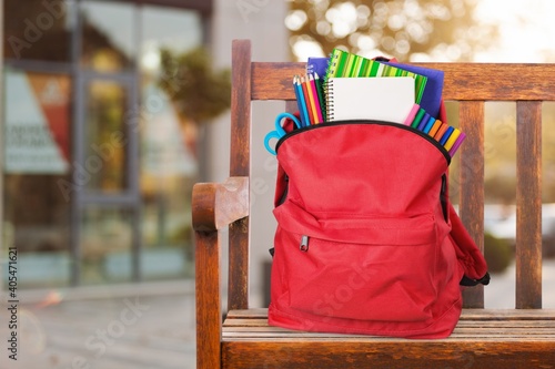 Modern schoolbag with various supplies for education