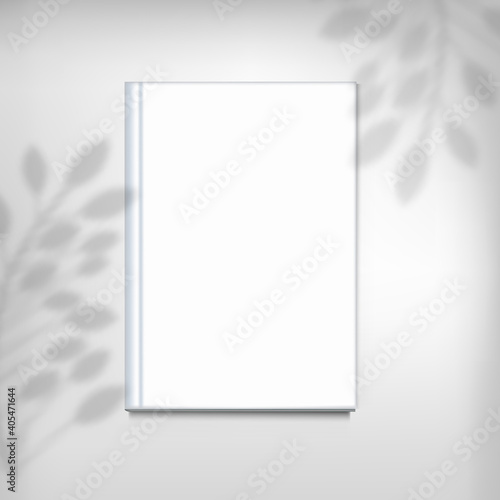 White book on background with a shadow of branch